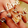 alwayswondered: A girl's hand wearing lots of rings, each of which spells 'love'. (fistful of love)