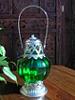 lanterne_rouee: small green lantern indoors on a table (green lantern 2)