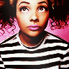 ex_we935: a black femme with curly pigtails, standing in front of a pink background (avory - portrait)